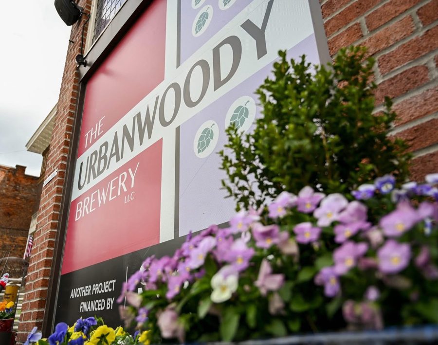 The UrbanWoody Brewery sign surrounded by purple flowers